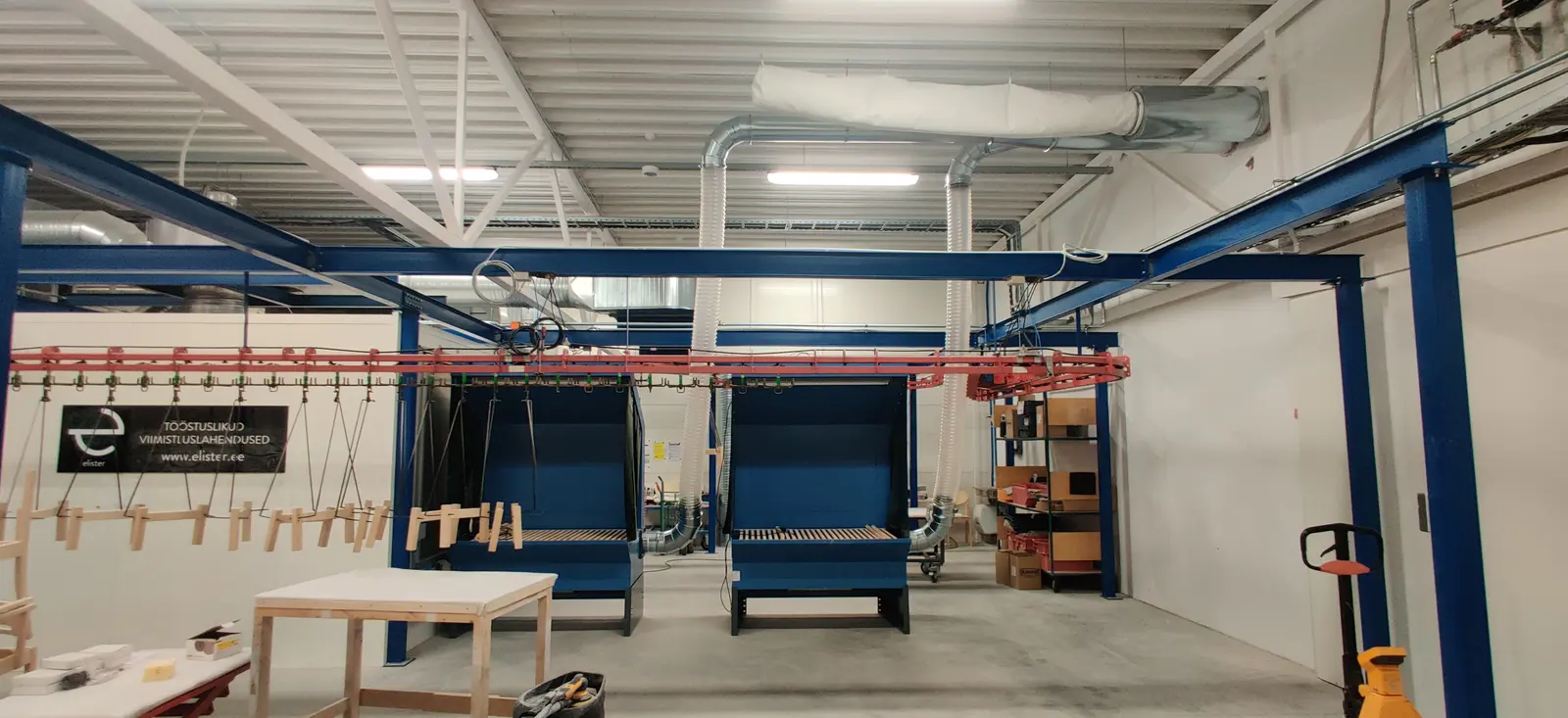 Booths and overhead conveyor line in a production hall