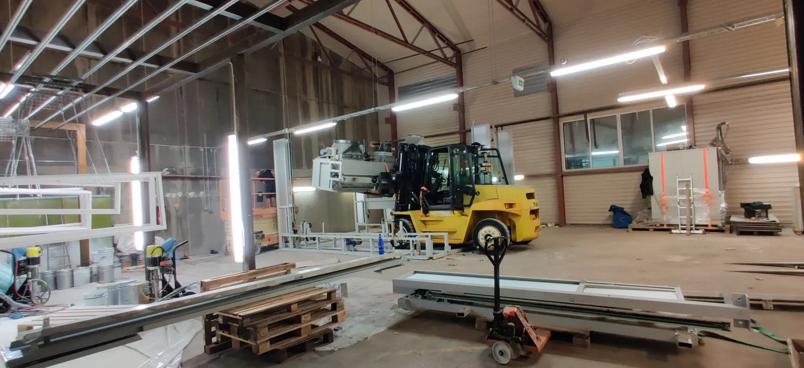 Forklift moving equipment in an industrial hall
