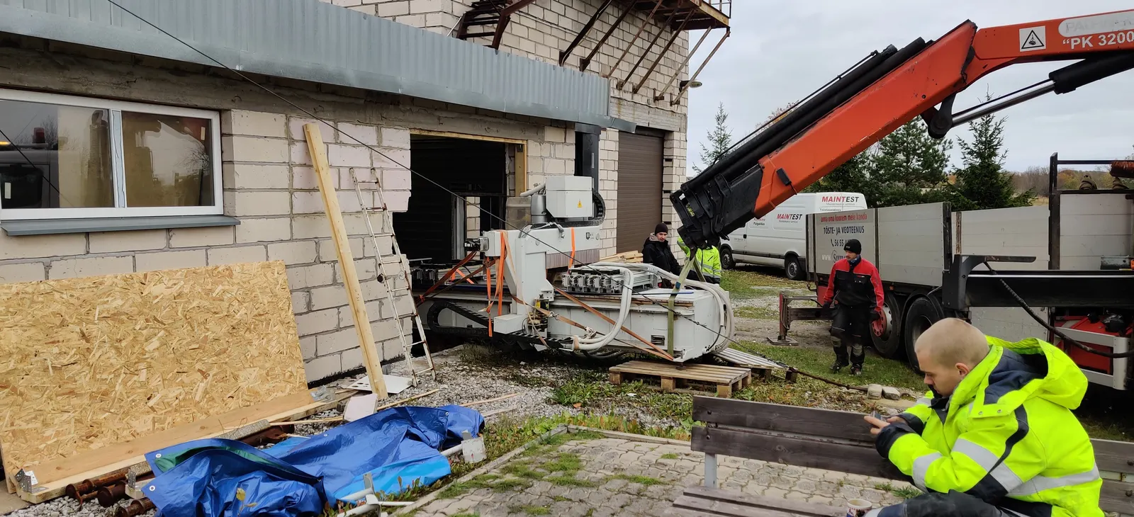 Truck-mounted crane unloading equipment at a site